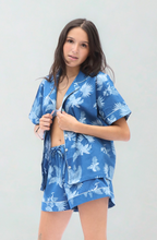 Load image into Gallery viewer, Woman wearing a blue pyjama set against a white background
