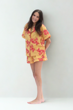 Load image into Gallery viewer, Woman wearing a yellow floral outfit against a white background