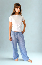 Load image into Gallery viewer, Woman wearing blue striped pants on a light gray background
