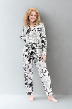 Load image into Gallery viewer, Woman wearing a black and white floral pajama set against a gray background
