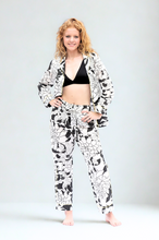 Load image into Gallery viewer, Woman wearing a black and white floral pyjama on a plain background
