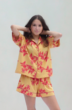 Load image into Gallery viewer, Person wearing a yellow floral pajama set on a plain background
