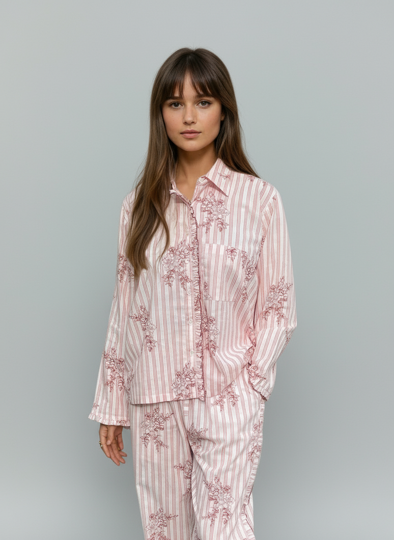 Woman wearing a pink striped and flower pyjama set against a gray background