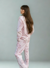 Load image into Gallery viewer, Woman wearing a pink striped and flower pyjama set against a gray background
