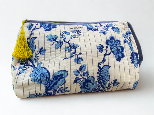 Floral-patterned pouch with a yellow tassel on a white background