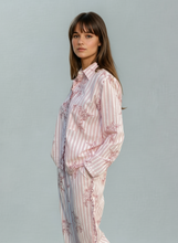 Load image into Gallery viewer, Woman wearing a striped and floral pyjama set on a gray background
