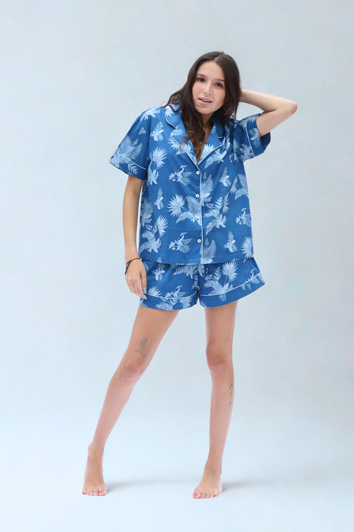 Woman wearing a blue floral pajama set on a light gray background