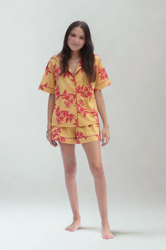 Woman wearing a yellow floral pajama set on a white background