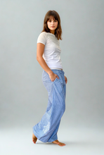 Load image into Gallery viewer, Woman wearing a white t-shirt and blue striped pants 
